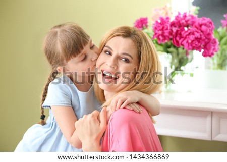 Little girl kissing her mother at home