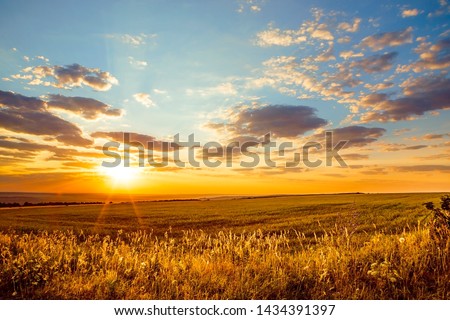 Saratov region, travel, landscape and nature of Russia. Yellow golden orange dramatic dawn at dawn or dusk over endless fields, hills, meadows. The sun rises in the morning above the horizon Royalty-Free Stock Photo #1434391397