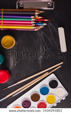 School supplies on blackboard background ready for your design.