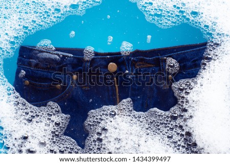 Jeans soak in powder detergent water dissolution, washing  cloth. Laundry concept