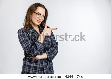 Young beautiful girl in a strict plaid suit posing on a white background. Emotions and feelings at work and office.