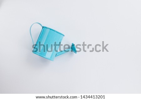 Iron blue watering can toy on a white background. Place for text. The concept of agriculture.