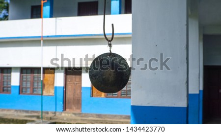 Indian School Bell Traditional icon, Behind the subject there is at glance of cosed school and the official Flag hosting post of Federal Democracy country of India.   