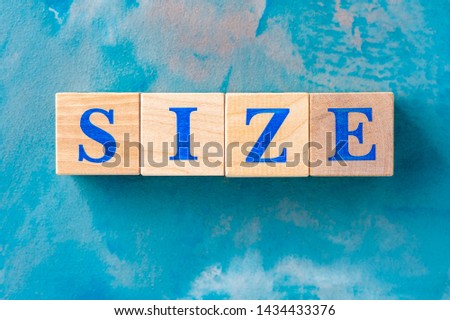 Wooden cubes with word SIZE on blue table. Cubes with blue letters.