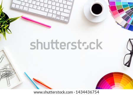 Pallet, keyboard, glasses, cup of coffee and tools for designer work on white desk background top view copyspace frame