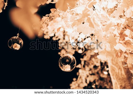 Wedding ceremony evening with candles and lamps. Electric yellow light bulbs on the street at night. Bulbs on the garland outside. Wedding ceremony decorations in grunge surround