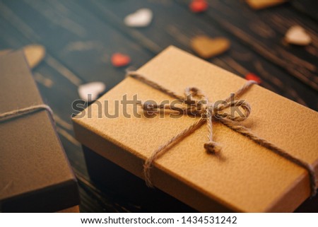 Two brown gift boxes on a wooden background with a bow of a simple rope on wood backgraund. Mother's day. Women's day. Valentine's day, Birthday greeting concept background.