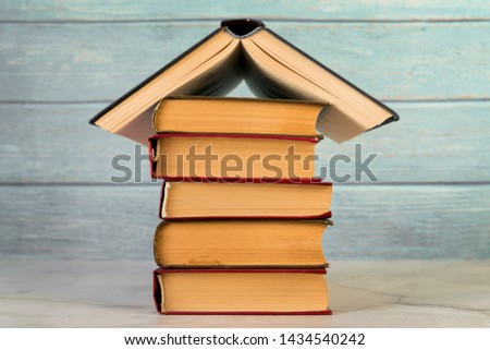 House structure made with vintage books against wooden wall Free Photo