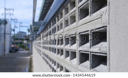 Close up and perspective view of brick block vents on concrete wall in construction site and blurred background 