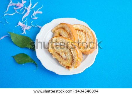 Sweet classic biscuit roll with peony on a blue background. Tomorrow for a girl