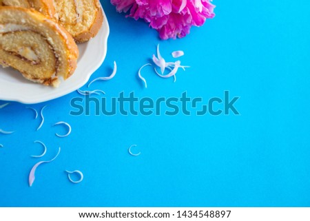 Sweet classic biscuit roll with peony on a blue background. Tomorrow for a girl