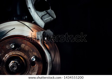 Car mechanic or serviceman checking a disc brake and asbestos brake pads it's a part of car use for stop the car for safety at front wheel this a new spare part for repair at car garage