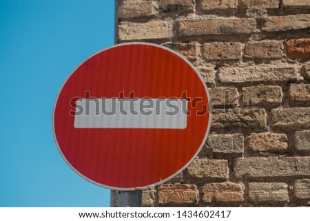 Road sign "Traffic is prohibited" hangs on the brick wall of a residential building.