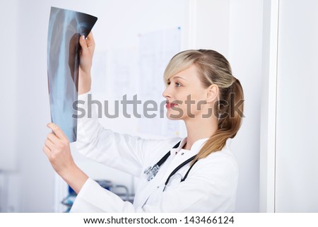 Cheerful blond doctor checking the x-ray image