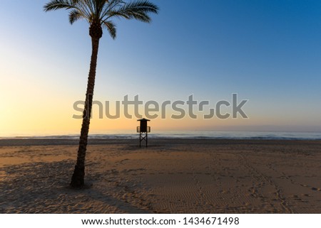 Stock picture of a lifeguard watchtower in silhouette, at Cullera beach in Spain.