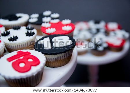 Delicious red and black chocolate cupcakes with 18 number on top of them. Birthday celebration