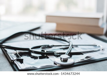 Medicine and health concept. Doctor’s office with books, patient’s card and stethoscope.