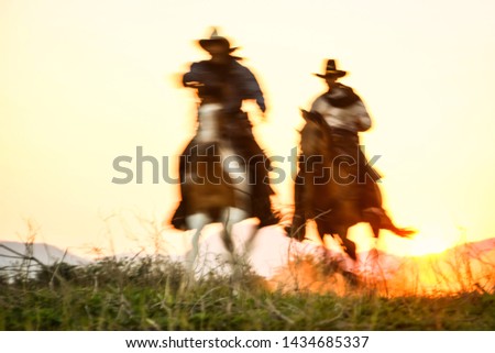 Blurred silhouette of a cowboy riding a horse