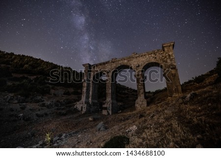 ruined ancient city  stone buildings and basilicas view under the milky way galaxy