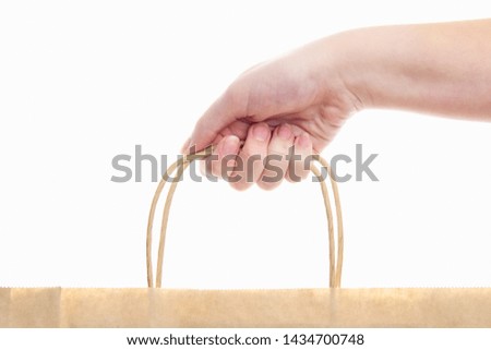 paper shopping bag in the hands of a girl on a white background