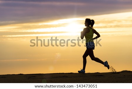 Woman running alone at beautiful sunset in the beach. Summer sport and freedom concept. Athlete training  on dusk. Royalty-Free Stock Photo #143473051
