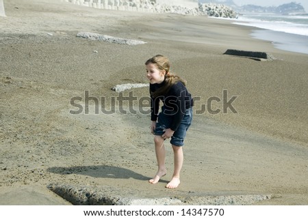 Happy barefoot young girl on the beach