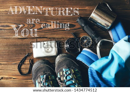 Accessories, backpack, shoes and utensils for hiking and adventure. Inspirational motivational quote: Adventures are calliing you.