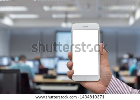Close up hand holding white smartphone on blank screen at office blur background clipping path inside