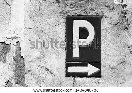 Parking sign on a raw stone wall