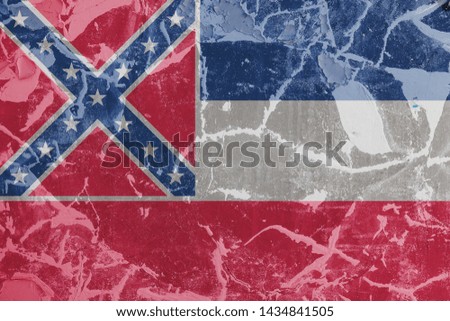 The national flag of the US state Mississippi in against a gray wall with cracks and faults on the day of independence in blue red and white. Political and religious disputes, customs and delivery.