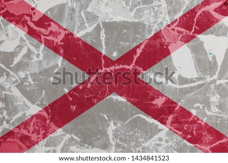 The national flag of the US state Alabama against a gray wall with cracks and faults on the day of independence in colors of red and white cross. Political and religious, customs and delivery.