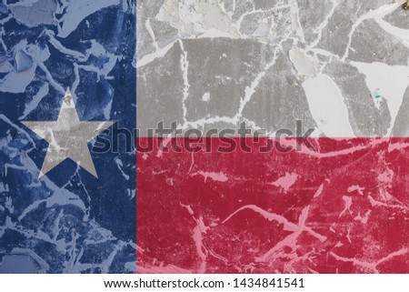 The national flag of the US state Texas in against a gray wall with cracks and faults on the day of independence in colors of blue red and white. Political and religious disputes, customs and delivery