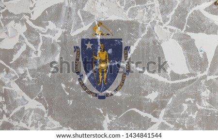 The national flag of the US state Massachusetts in against a gray wall with cracks and fault on the day of independence in blue white and yellow. Political and religious disputes, customs and delivery