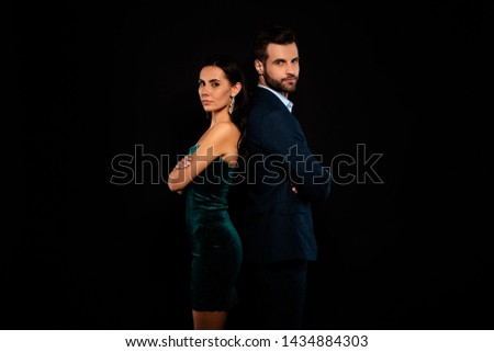 Close up side profile photo amazing pair she her chic he him his macho stand back to back arms crossed best partnership wear blue costume jacket green glossy velvet dress isolated black background