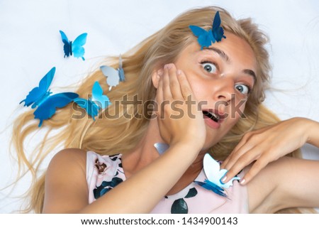 Portrait of a cute beautiful pretty woman girl with long beautiful hair on a white background with decorative butterflies. Made in a studio.