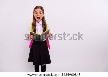 Portrait of  nice attractive lovely intelligent cheerful cheery positive overjoyed pre-teen girl nerd holding in hands exercise book isolated over light white grey background