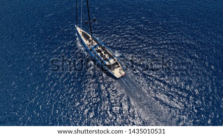 Aerial drone photo of beautiful wooden deck sail boat cruising the deep blue sea of Mykonos island, Cyclades, Greece