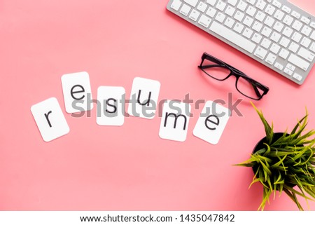 Resume copy on work place with keyboard and glass on pink desk background top view