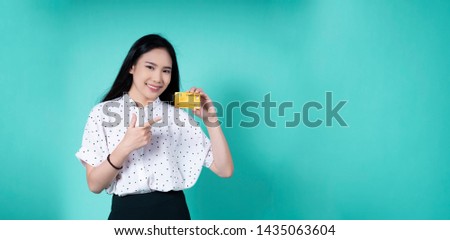 credit card career e-commerce trading Technology, Online shopping, Digital banking,Smiling Asian woman show credit card for business payment on a blue isolated background for banner website copy space