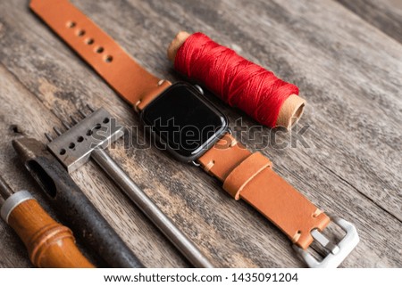 Craft working of leather watch strap on wood table