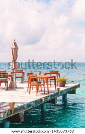 empty outdoor wood table and chair with sea view background in Maldives