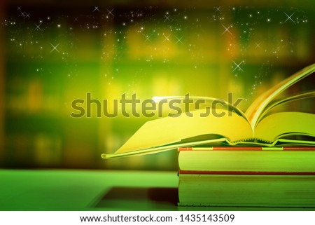 Open book on the table and Stars Floating above the book in the library and blur bookshelf background.