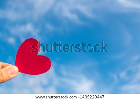Hand’s people show red heart paper and blue sky with clouds. Concept for valentine 's day theme ,Holiday ,Postcard ,Romantic card ,Day off ,Wedding marriage love card.