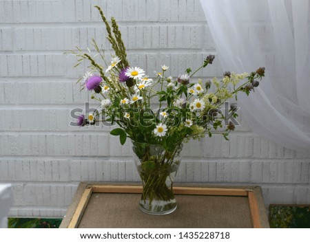 bouquet of wild flowers on a white brick background