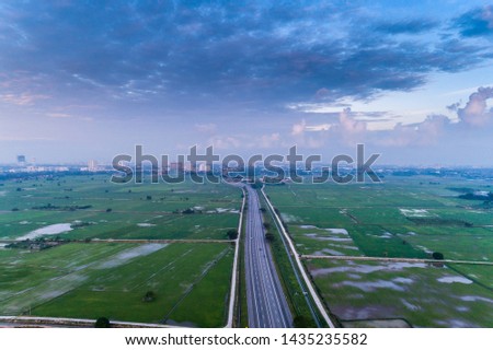 Scenic sunrise with the aerial view of paddy field and expressway in northern of Malaysia