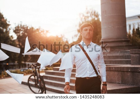 Leaving the project behind. Businessman in formal clothes with black bicycle is in the city.