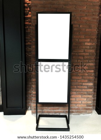 Two mock up posters with black frames. Billboard, mock up for advertising and promotion. In front of brick wall. White background.