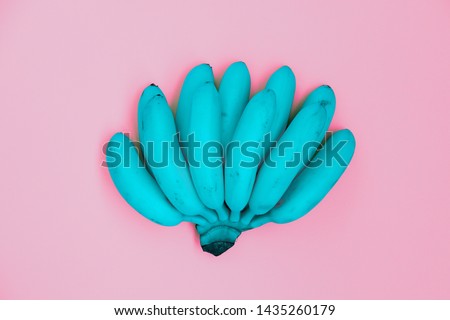 Turquoise bananas in bunch top view on pink backdrop. Summertime vibrant concept. Ripe fresh juicy exotic fruit pop art style. Vintage tropical vivid banana. Simple creative wallpaper, background Royalty-Free Stock Photo #1435260179