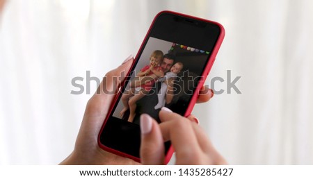Woman hand with smartphone showing kid picture on white background
