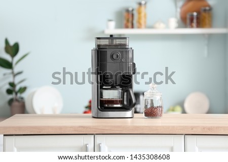 Modern coffee machine on table in kitchen Royalty-Free Stock Photo #1435308608